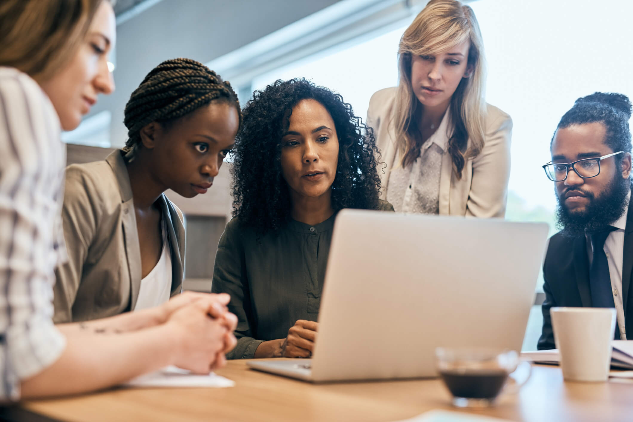 group of focused businesspeople browsing on a laptop